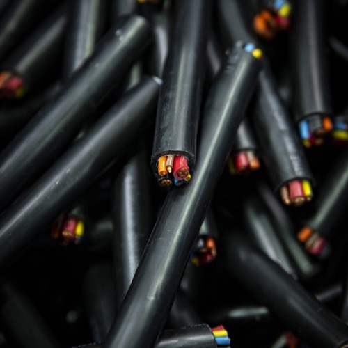 A closeup of a pile of clipped black wires exposing multi-colored core wires